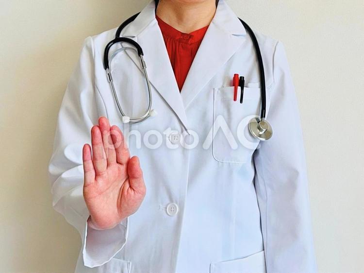 ストップ！と手を前に出す女性医師 ストップ,禁止,ダメの写真素材