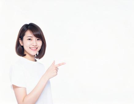 ポイントを指差す笑顔の女性 ポイントを指差す笑顔の女性の写真
