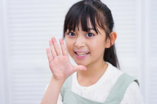 元気に挨拶をする少女の笑顔の写真