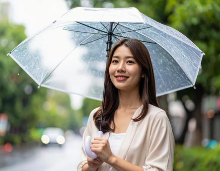 雨の日に傘をさしている若い女性 雨の日に傘をさしている若い女性の写真