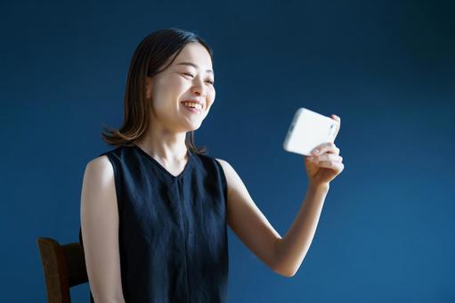 スマートフォンを手にする女性  スマホ,女性,スマートフォンの写真素材