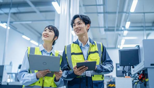 工場でタブレットで製品を検査する作業員 工場でタブレットで製品を検査する作業員の写真