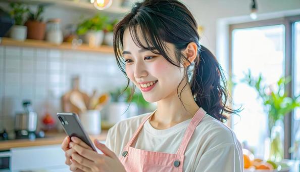 スマホでポイ活する笑顔の女性 スマホでポイ活する笑顔の女性の写真