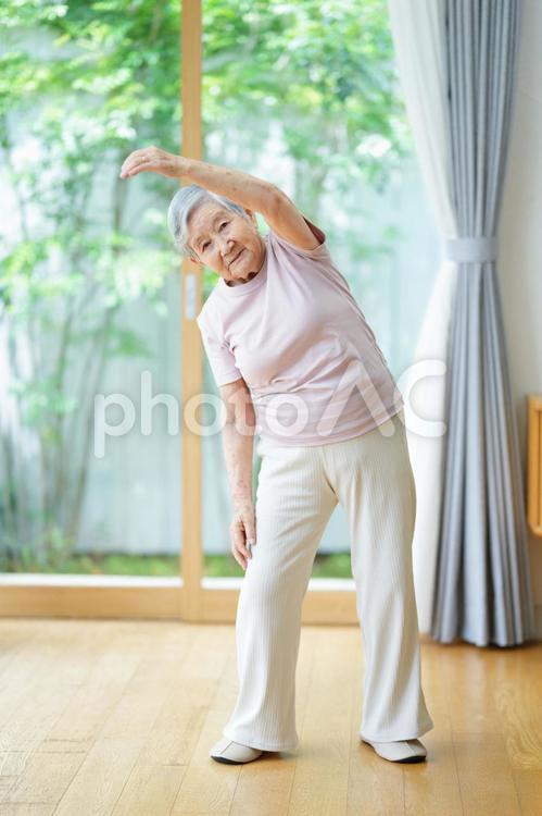 カメラ目線で左腕を伸ばして体操する高齢女性 女性,体操,伸ばすの写真素材