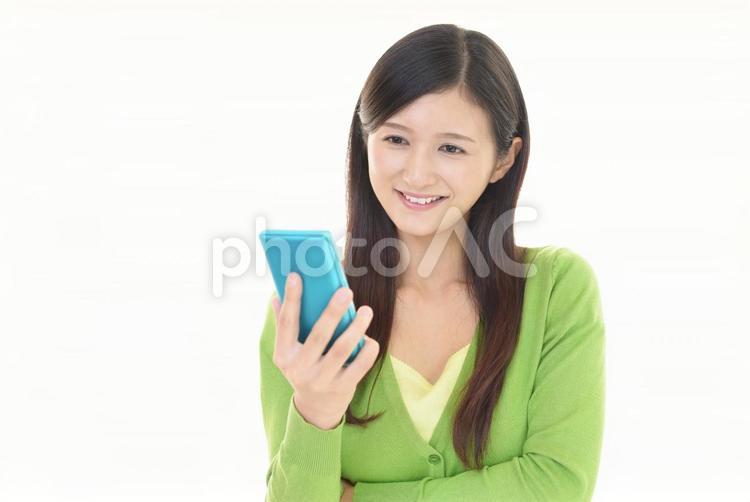 スマートフォンを持つ笑顔の女性 女性,スマホ,スマートフォンの写真素材