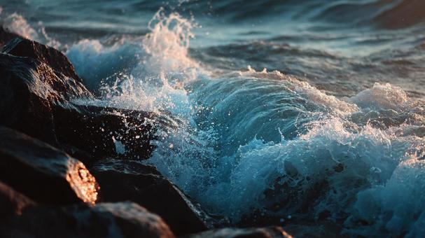 力強く砕ける波と海岸の岩の写真