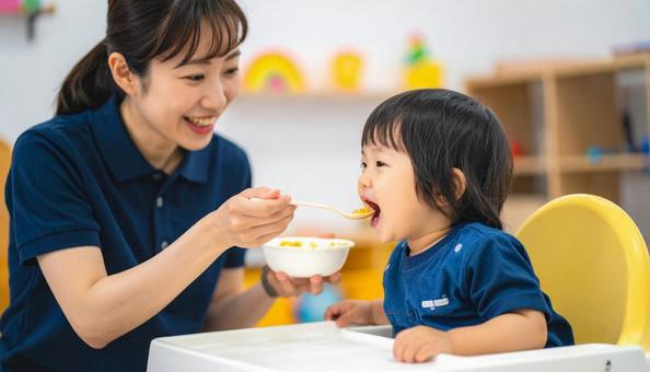 子どもにご飯をあげる保育士 子どもにご飯をあげる保育士の写真
