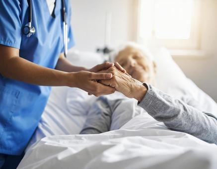 ベッドで横になる患者と握手、医療従事者 ベッドで横になる患者と握手、医療従事者の写真