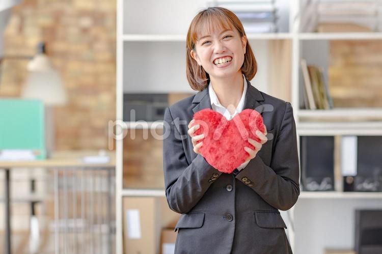 ハートを持ったビジネスウーマン 笑顔,女性,スーツの写真素材