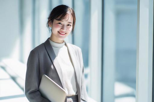 ノートパソコンを持つビジネスウーマンの写真