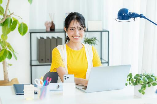 ノートパソコンを使う若い女性 笑顔,若い女性,ビジネスウーマンの写真素材