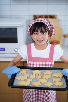 ミトンをつけて焼けたクッキーをもって微笑む女の子 女の子,日本人,クッキーの写真素材