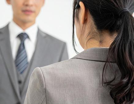 男性上司に怒られ、謝る女性社員の写真