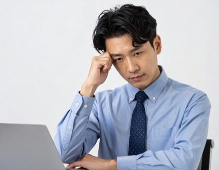 頭を抱えて頭痛に悩む男性 頭を抱えて頭痛に悩む男性の写真
