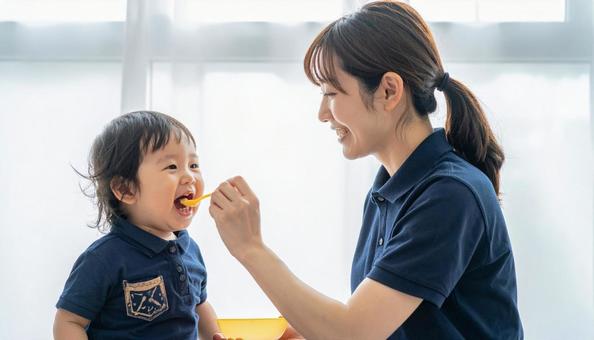 子どもにご飯をあげる保育士 子どもにご飯をあげる保育士の写真
