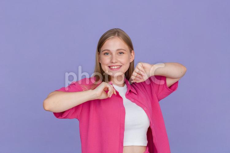 笑顔でカメラ目線で脇をあげる女性 女性,カメラ目線,若者の写真素材