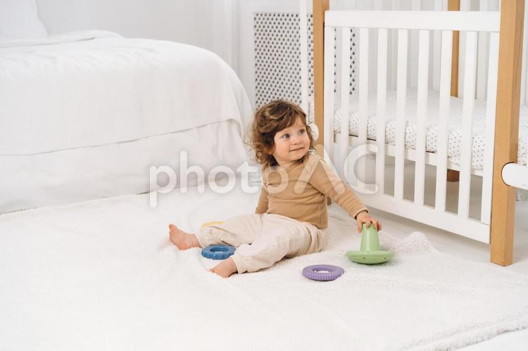 お座りして玩具に触れ振り向く子供 赤ちゃん,かわいい,お座りの写真素材