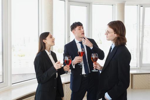 グラスを持ち談笑するスーツの男女 男女,外国人,ビジネスの写真素材