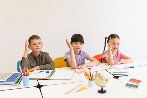 座って手を挙げる生徒たち 男の子,女の子,子どもの写真素材