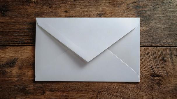 木目テーブルに置かれた白い封筒の写真