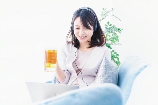 オンラインで乾杯をする若い女性 オンラインで乾杯をする若い女性の写真
