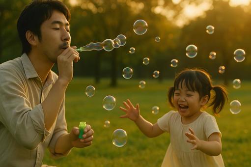 シャボン玉と笑顔の親子の写真