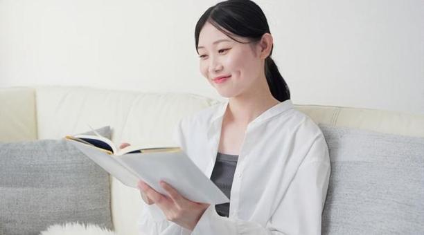 自宅で読書をするアジア人女性 自宅で読書をするアジア人女性 女性,読書,リビングの写真素材