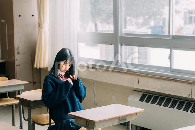 教室の机に座っていじける女子高校生 女子高校生,高校生,学生の写真素材
