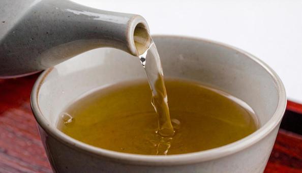 白い湯のみにお茶を注ぐ 白い湯のみにお茶を注ぐの写真