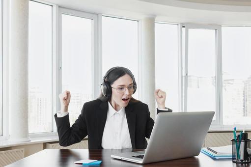 パソコンを見てガッツポーズで喜ぶ女性 女性,外国人,ガッツポーズの写真素材