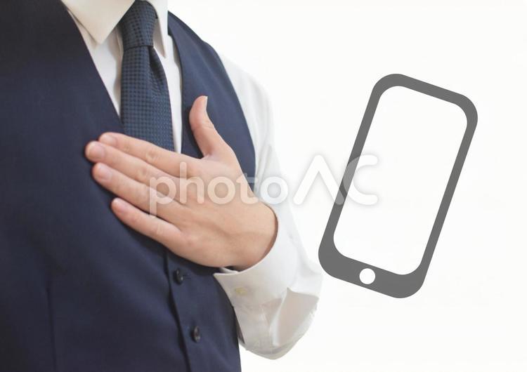 胸に手を当てるビジネスマンとスマホ iphone,携帯,スマートフォンの写真素材