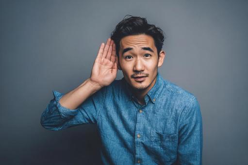 「何?」と聞き耳を立てるアジア人男性 「何?」と聞き耳を立てるアジア人男性の写真