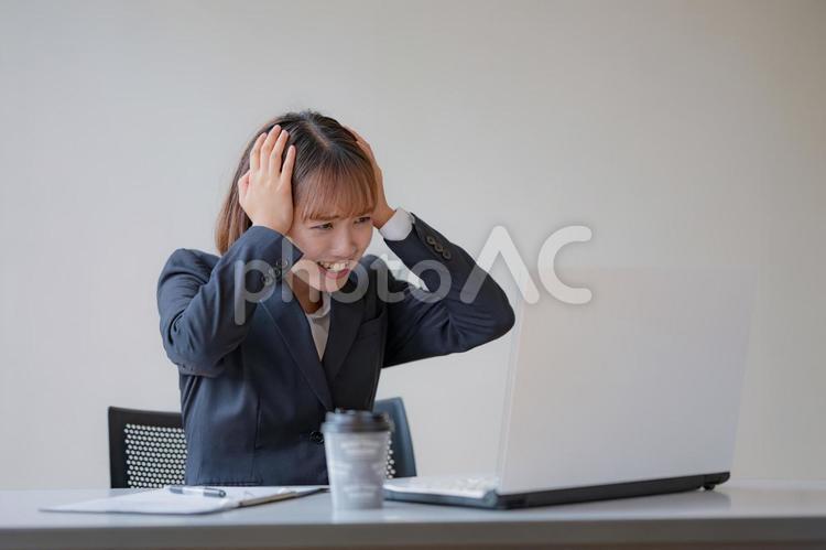 頭を抱えるビジネスウーマン 女性,ビジネスウーマン,ビジネスマンの写真素材