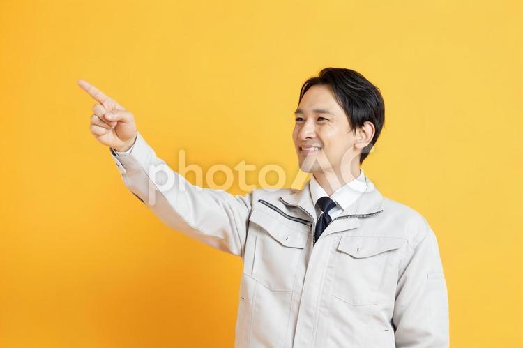 笑顔で指差しをする男性作業員 イケメン,ハンサム,プロフィール写真の写真素材