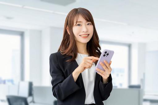 スマホを使う笑顔の女性・ビジネスウーマン 女性,スマホ,スマートフォンの写真素材