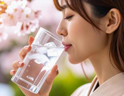 コップに入った氷入りの水を飲む日本人女性 コップに入った氷入りの水を飲む日本人女性の写真