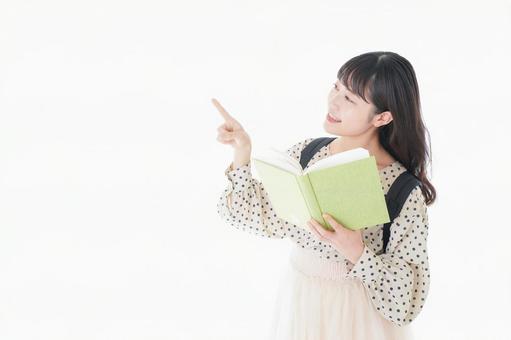 上を指差す制服を着た女子学生 発見,コピースペース,社会科見学の写真素材