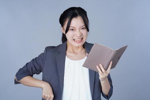 グレーの服の女性が手帳を広げる 女性,手帳,本の写真素材