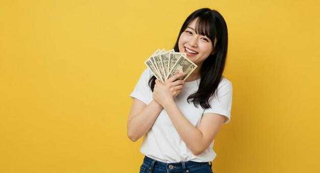 お札を手にして喜ぶ女性 お札を手にして喜ぶ女性の写真