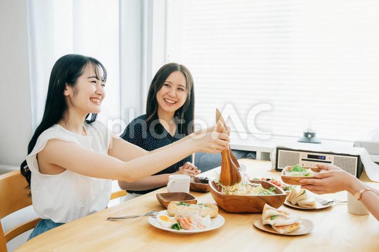 家でパーティーする女性たち（サラダ・取り分ける） ランチ,女子会,食事の写真素材