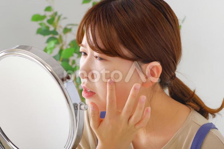 お肌の状態を気にしている女性 シミ,シワ,そばかすの写真素材