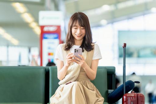空港でスマホを使う旅行中の女性 空港でスマホを使う旅行中の女性 女性,旅行,空港の写真素材