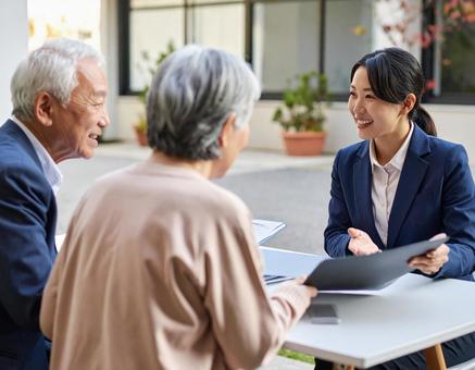 シニア夫婦と打ち合わせする女性社員 シニア夫婦と打ち合わせする女性社員の写真
