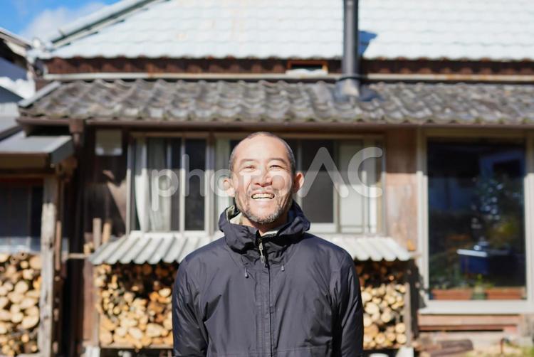 古民家の庭で笑顔の男性 笑顔,屋外,パーカーの写真素材