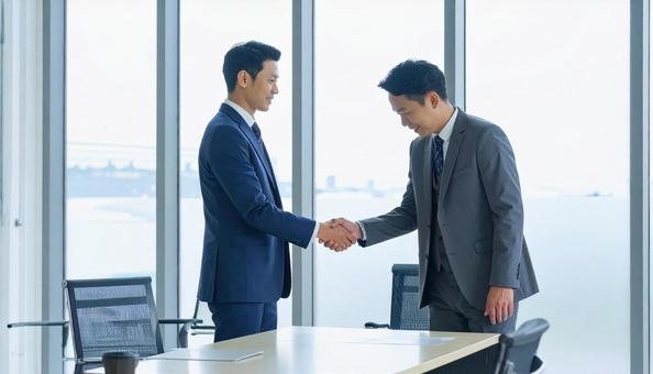 握手しながら謝罪するビジネスマン 握手しながら謝罪するビジネスマンの写真
