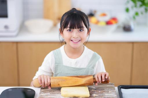 料理を手伝う笑顔の女の子 女の子,めん棒,持つの写真素材