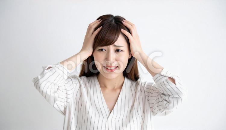 困惑した表情で頭を抱えるシャツの女性 人物,困惑,ネガティブの写真素材