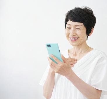 スマホ 受信 60・70代 女性 白背景 スマホ 受信 60・70代 女性 白背景の写真