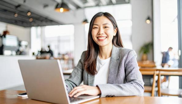 カフェでテレワークする若い日本人女性 カフェでテレワークする若い日本人女性の写真