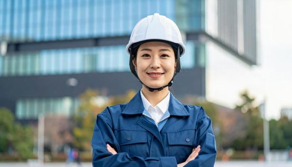 高層ビルの背景に作業服の笑顔の若い女性 高層ビルの背景に作業服の笑顔の若い女性の写真